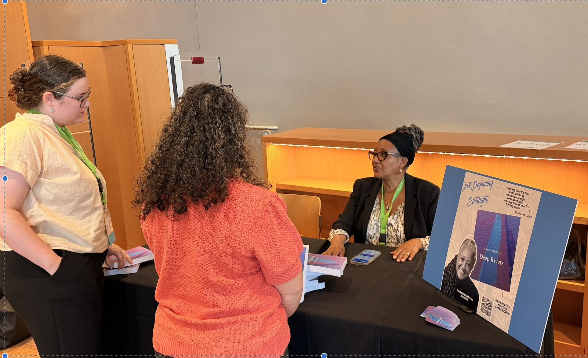 two people talking to author at book table